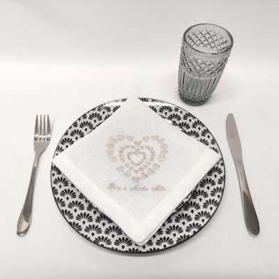 Conjunto de jantar com prato preto e branco, guardanapo bordado, talheres de aço inox e copo texturizado