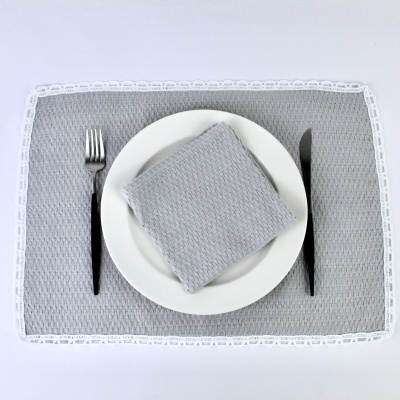 Conjunto de utensílios de mesa com individual cinzento e guardanapo dobrado