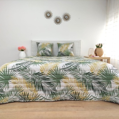 Conjunto de cama tropical com padrão de folhas verdes e amarelas e cabeceira branca