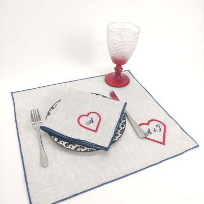 Conjunto de guardanapo e toalhete bordados com coração e iniciais, prato decorado, talheres e copo vermelho