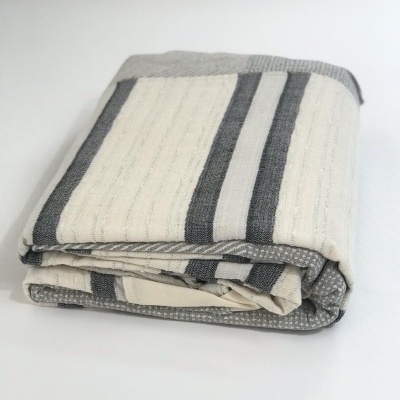 toalha ou manta dobrada com riscas cinza e branco