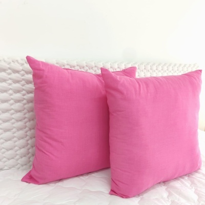 Duas almofadas cor de rosa sobre superfície branca acolchoada