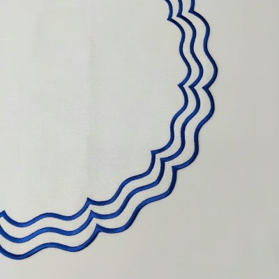 Pano branco com bordado azul em padrão ondulado