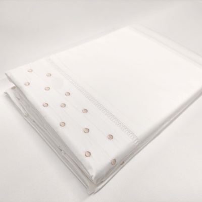 Lençol branco com bordado de círculos beige na borda