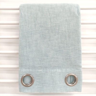 Cortina azul claro com ilhós metálicos prateados pendurada