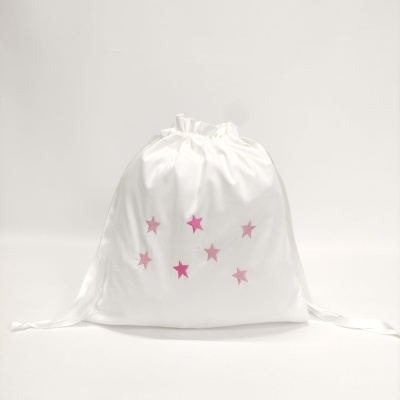 Saco branco em tecido com estrelas rosa e cordões de fecho