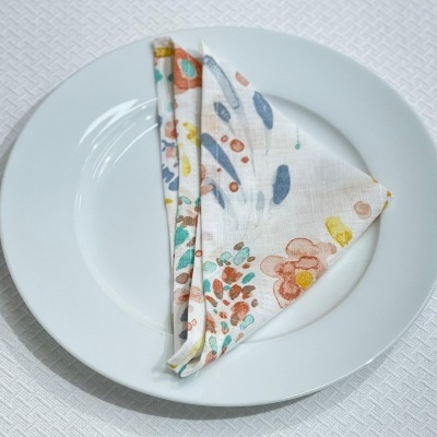 Prato branco com guardanapo floral colorido dobrado