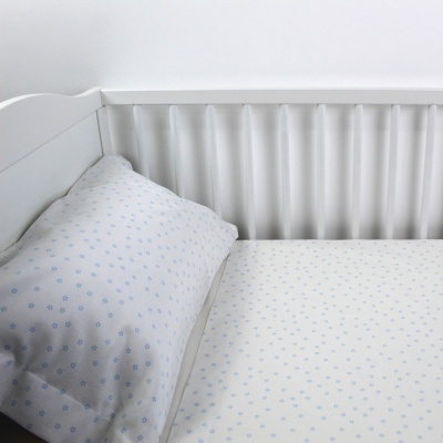 Berço branco com colchão e almofada de padrão azul