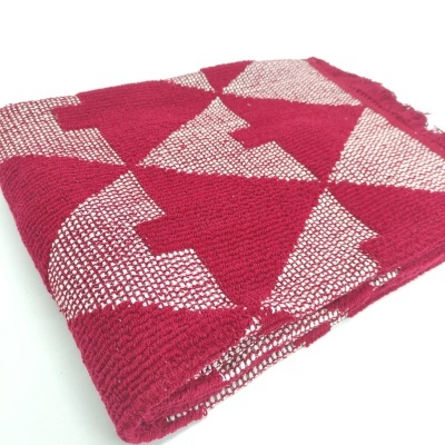 Manta dobrada com padrão geométrico vermelho e branco