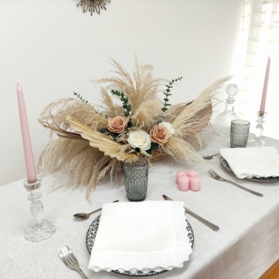 Mesa de jantar decorada com flores artificiais e velas cor-de-rosa