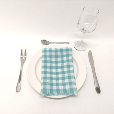 Conjunto de louça com prato, talheres, copo de vinho e guardanapo quadriculado azul e branco