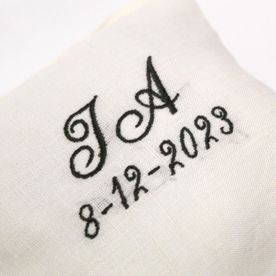 Toalha branca com bordado preto das letras J A e data 8-12-2023