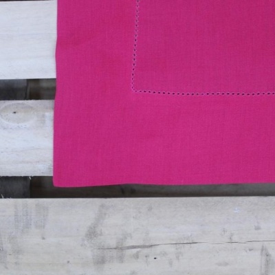 Tecido rosa com costura sobre superfície de madeira clara