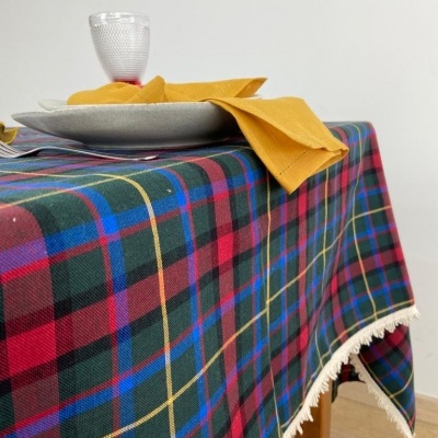 Toalha de mesa xadrez colorida com prato cinza, guardanapo amarelo e copo de vidro