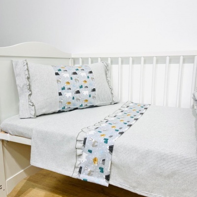 Cama de criança com roupa de cama riscada e padrão de animais coloridos