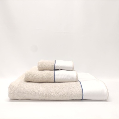 Toalhas empilhadas bege e branca com faixa azul