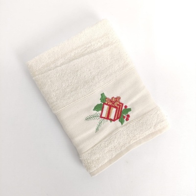 Toalha branca com bordado de presente e folhas verdes