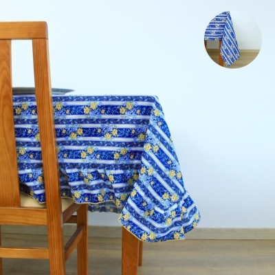 Toalha de mesa azul com flores amarelas em mesa de madeira