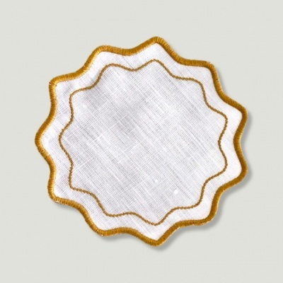 Guardanapo branco com bordas onduladas bordadas em dourado
