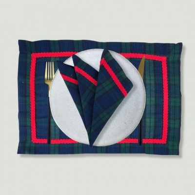 Jogo americano e guardanapo xadrez azul e verde com detalhes vermelhos, prato branco e talheres dourados