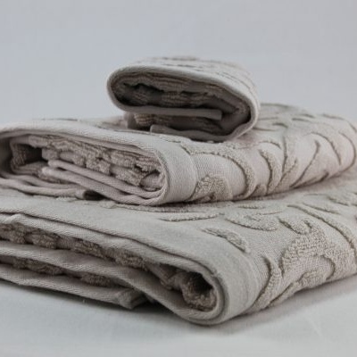 Toalhas bege com padrão floral bordado empilhadas