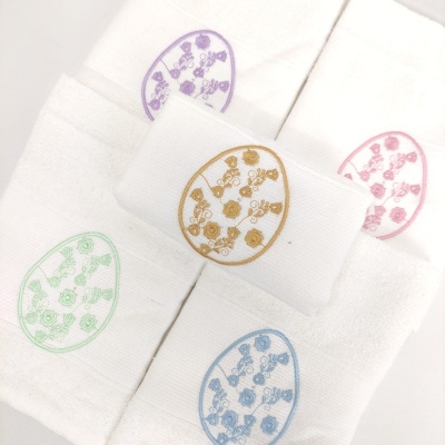 Toalhas de mão brancas com bordados ovais coloridos em padrão floral.