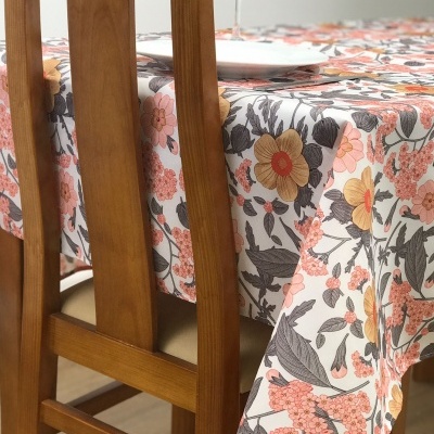 Toalha de mesa floral colorida numa mesa de madeira com prato e taça