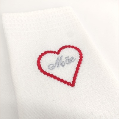 Toalha branca bordada com coração vermelho e palavra Mãe em cinzento
