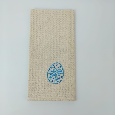 Toalha bege texturizada com bordado azul de ovo