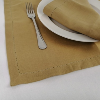Jogo americano e guardanapo bege com prato branco e garfo