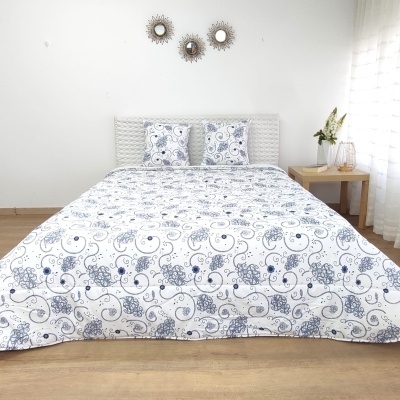 Cama com capa de edredão e almofadas florais azuis e brancas