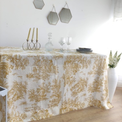 Toalha de mesa branca com padrão floral dourado e decoração em cima
