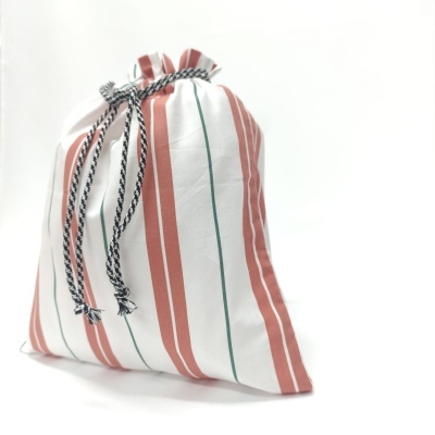 Saco de tecido com riscas vermelhas e verdes e cordão preto e branco