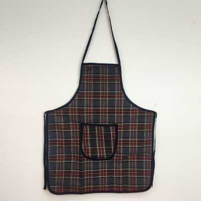 Avental xadrez cinza, vermelho e amarelo com bolso frontal, pendurado numa parede branca.