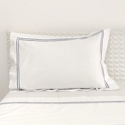 Fronha branca com linhas azuis finas em fundo branco e textura atrás