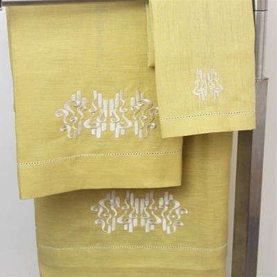 Toalhas amarelas bordadas em suporte metálico