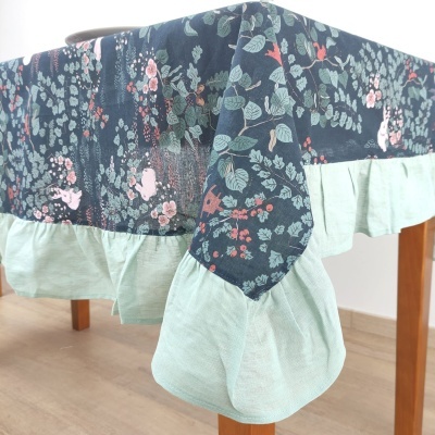 Toalha de mesa floral com borda verde claro em mesa de madeira