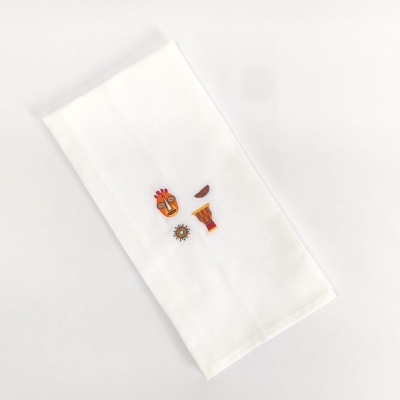 Toalha branca com bordados coloridos representando elementos culturais