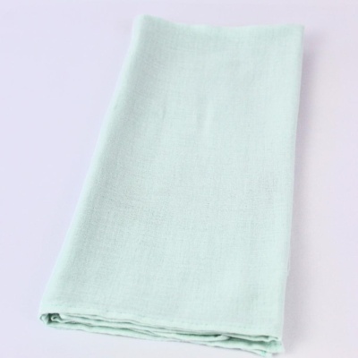 Toalha verde clara dobrada sobre superfície branca