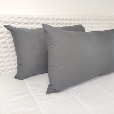 Almofadas cinzentas sobre sofá branco com padrão texturizado