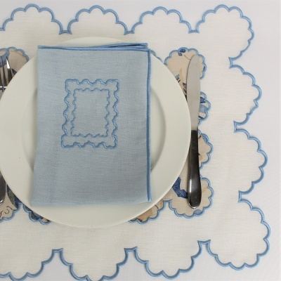 Toalha de mesa e guardanapo branco com bordado azul em nuvens, prato branco e talheres