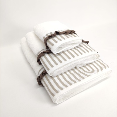 Três toalhas brancas com padrão bege e bordas castanhas empilhadas