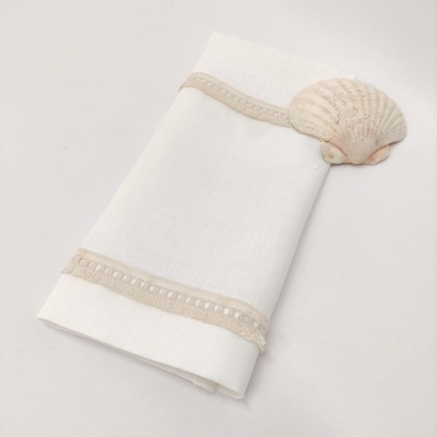 Guardanapo branco com bordado bege e mola de concha decorativa