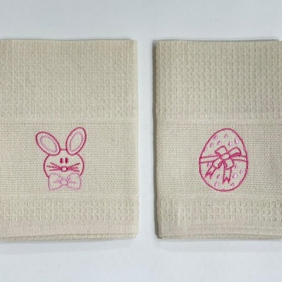 Dois panos de cozinha bege com bordados rosas de coelho e ovo decorado