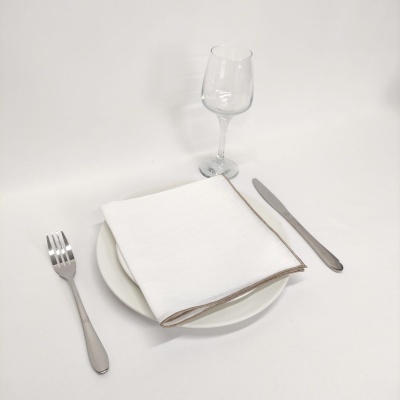 Conjunto de mesa com talheres em metal, prato branco, guardanapo branco e copo transparente