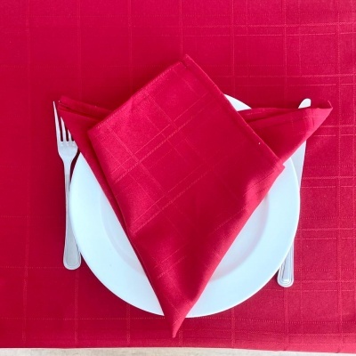 Conjunto de mesa com toalha e guardanapo vermelhos, prato branco, garfo e faca