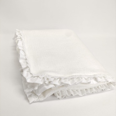 Toalha branca com folhos dobrada sobre fundo branco
