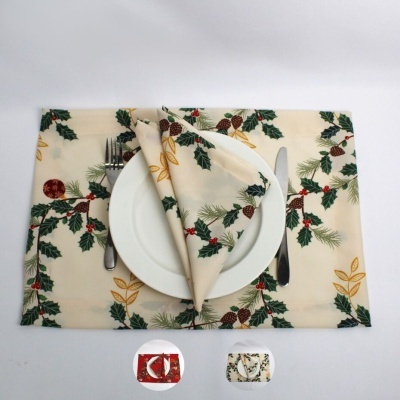 Jogo americano e porta-guardanapo decorados com padrão natalício de folhas verdes, pinhas e bagas vermelhas