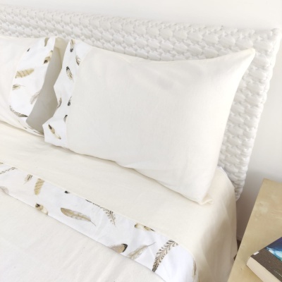 Conjunto de roupa de cama branca com padrão de penas em tons castanhos e cinzentos