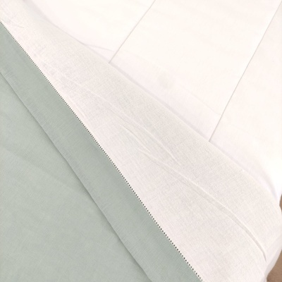 Roupa de cama branca e verde-acinzentada com padrão simples